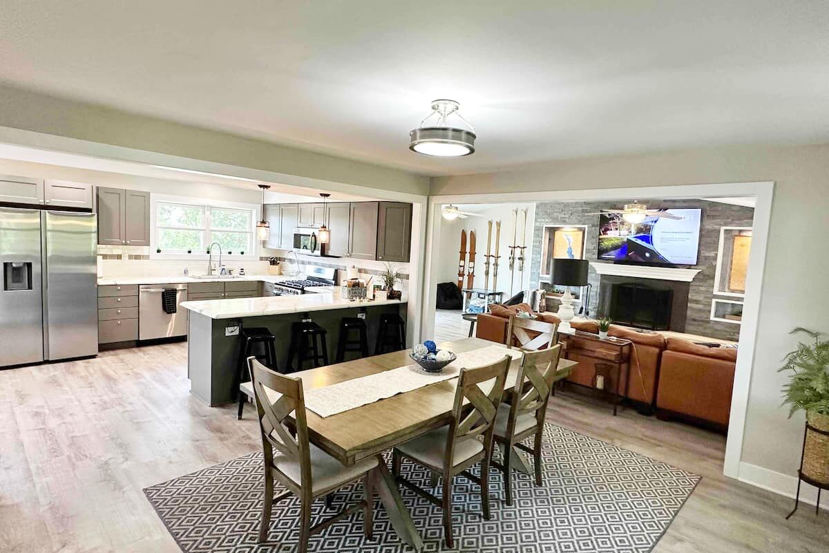 Dining table, kitchen island, and living room seen from the front door.